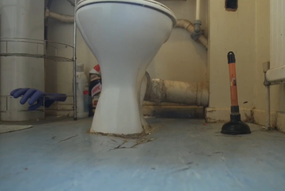 The toilet is sinking into the floor due to the damp