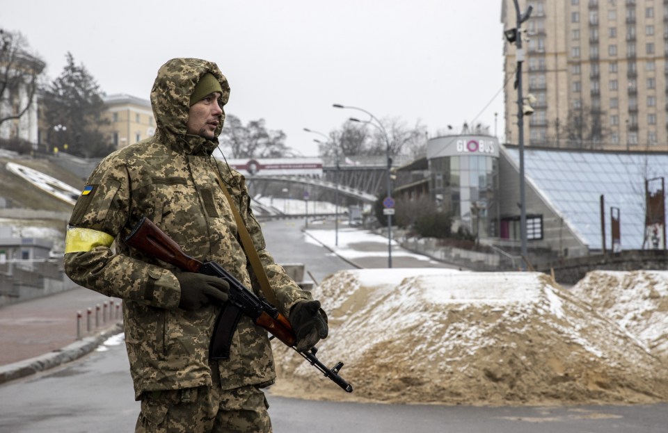 Soldiers stand guard amongst the barricades in Kyiv