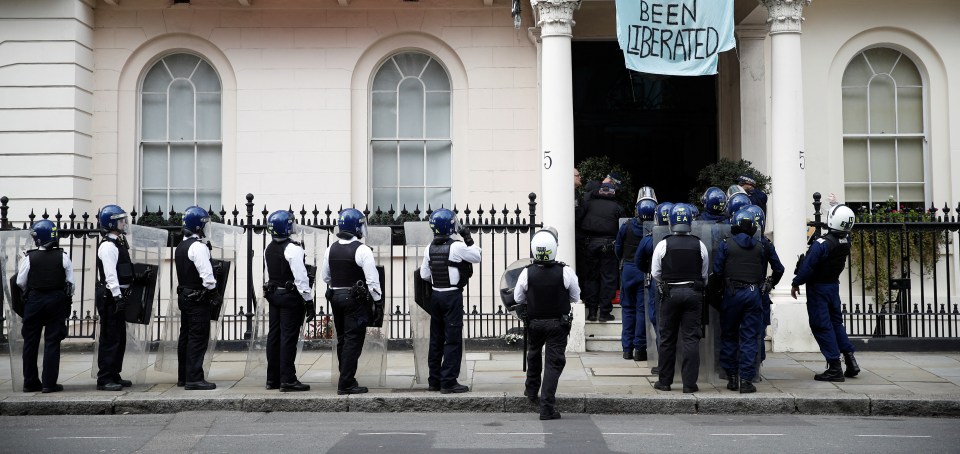 Police with riot gear lined up to storm the house