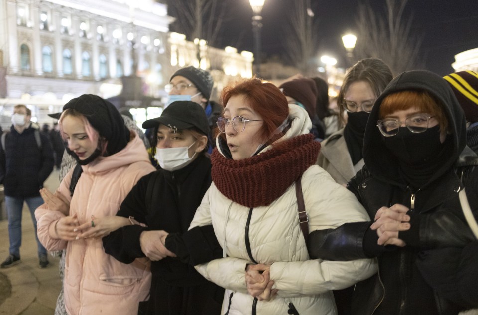 Women linking arms in an anti-war demonstration in St Petersburg