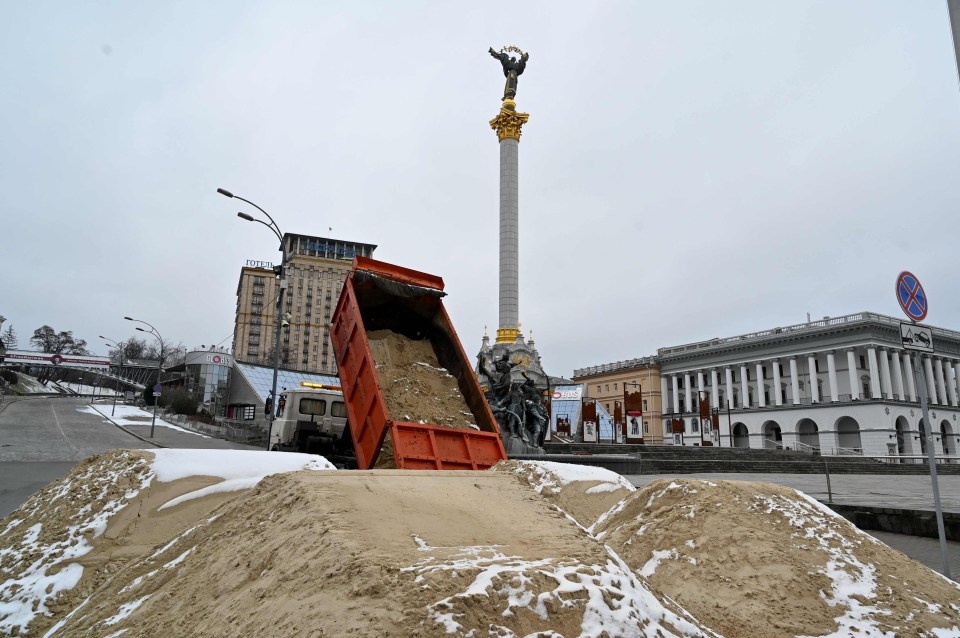 Sand is dumped on the street is Kyiv to act as a makeshift barricade