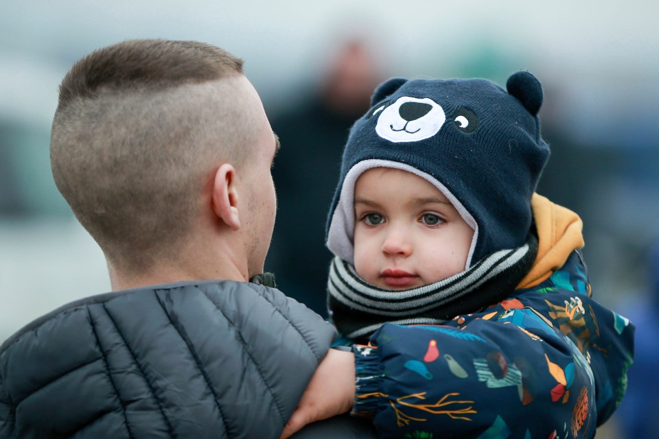 A man is reunited with a child after they crossed the border at Medyka, south-eastern Poland