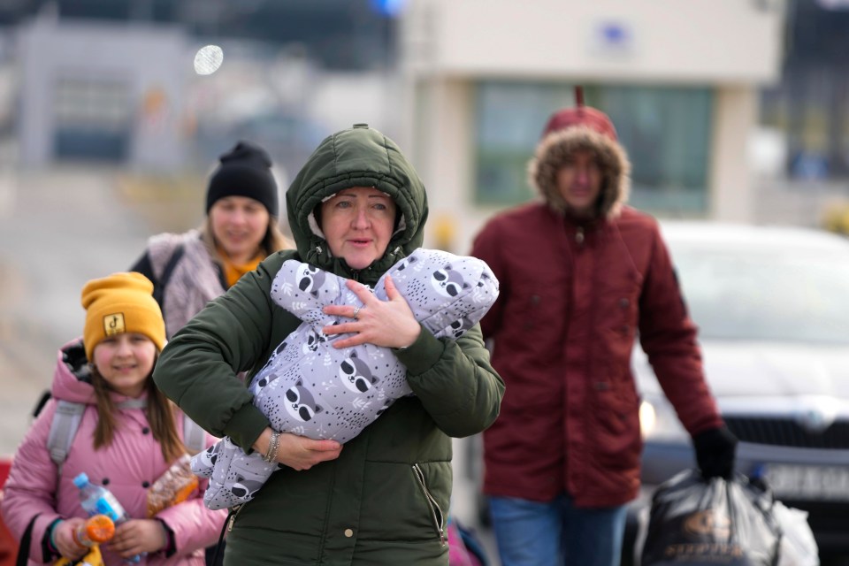 A family fleeing Russian troops by crossing from Ukraine into Poland.