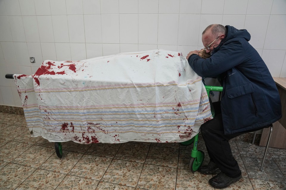 The mourning dad was pictured cradling his son’s body