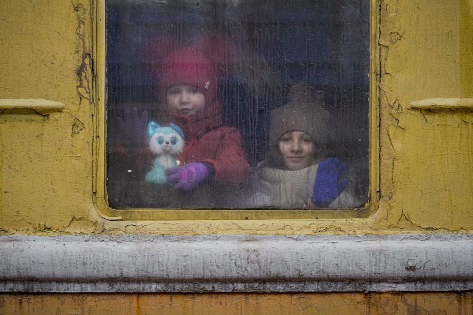 Children look out the window of a Lviv bound train in Kyiv