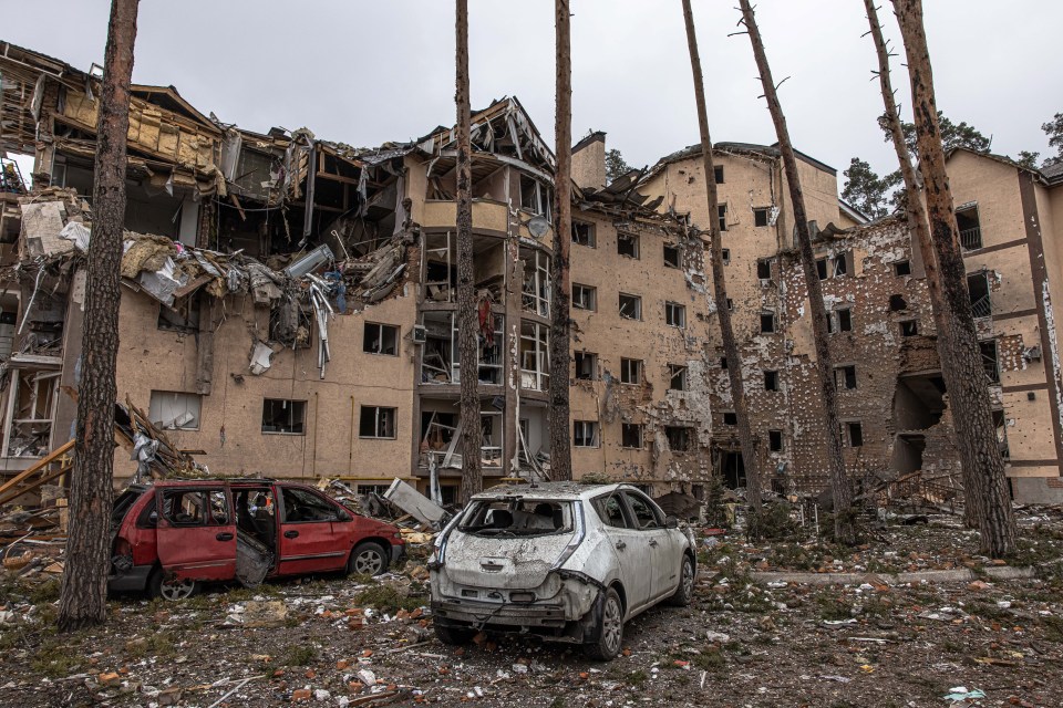 Destroyed cars next to residential buildings damaged by heavy shelling in Irpin, Ukraine