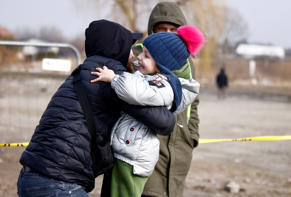 The girl had spotted her father in the distance and ran as fast as she could into his arms for a hug