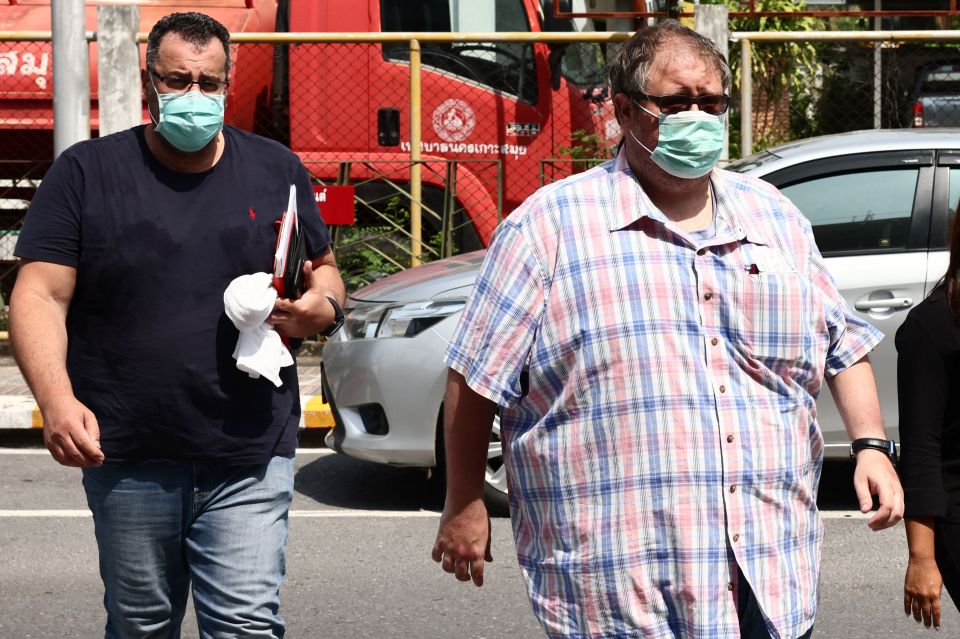 Friend Andrew Neophitou, left, arrives at a police station on Koh Samui