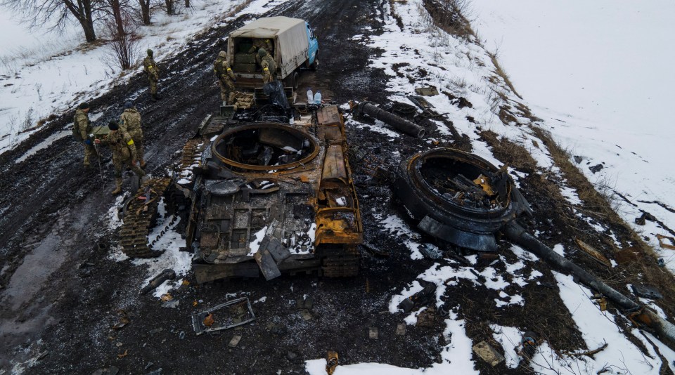 Ukrainians inspect a charred Russian tank in Sumy