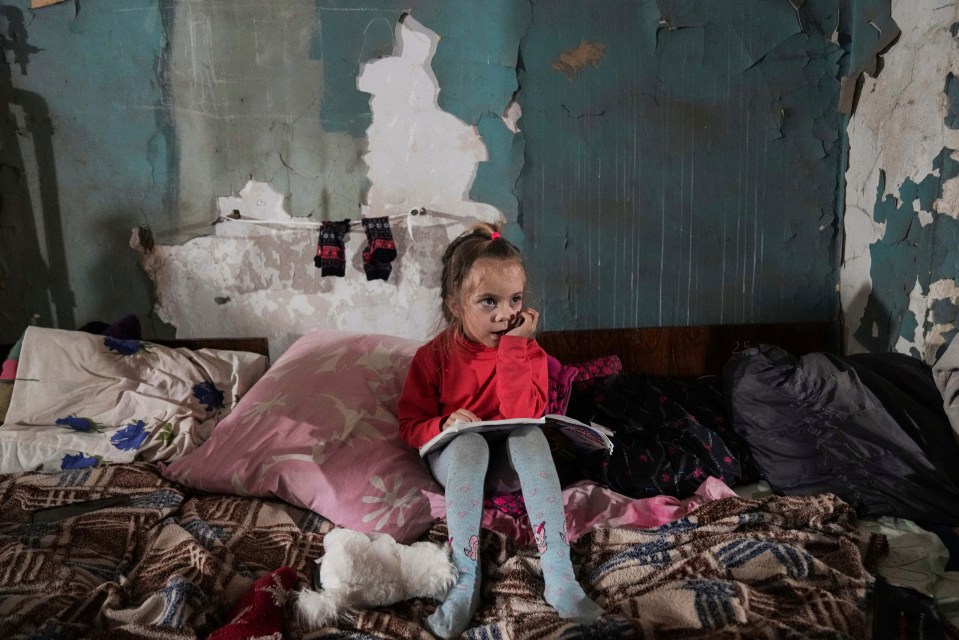 A girl sits in the improvised bomb shelter in Mariupol