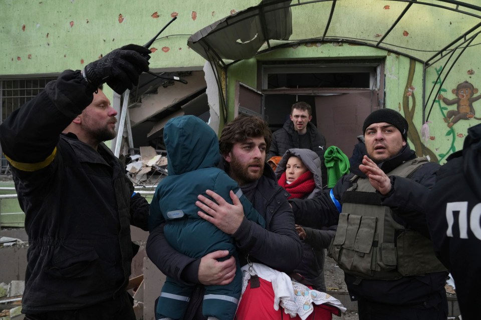 A dad pictured carrying his child after the airstrike