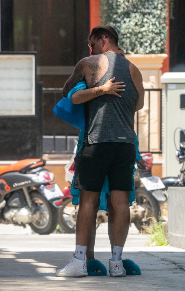 Carl, dressed in a vest and shorts, gave Katie a hug as she headed in