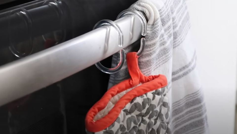 Kristen used shower curtain hooks to hang oven mitts on her oven door