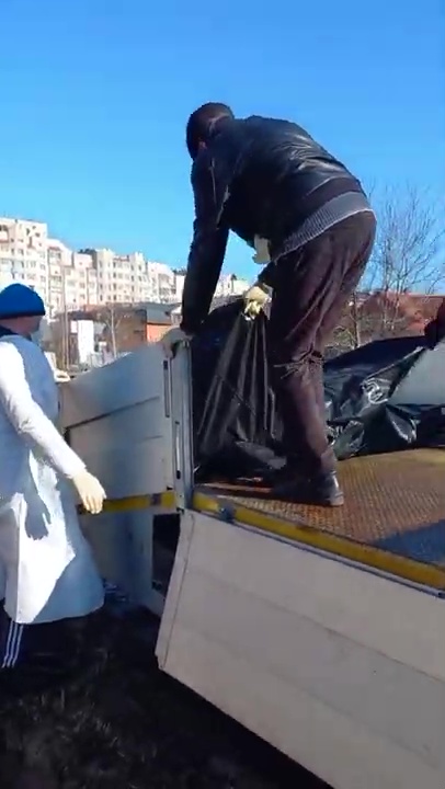 Footage shows the bodies being unloaded from a truck before being place in a mass grave near Kyiv