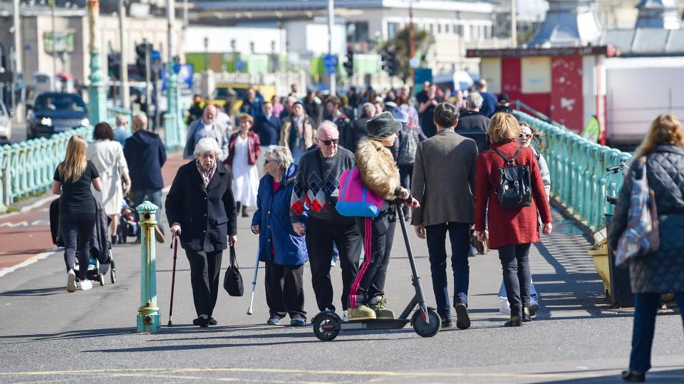 Visitors soak up the rays on the seafront in Brighton