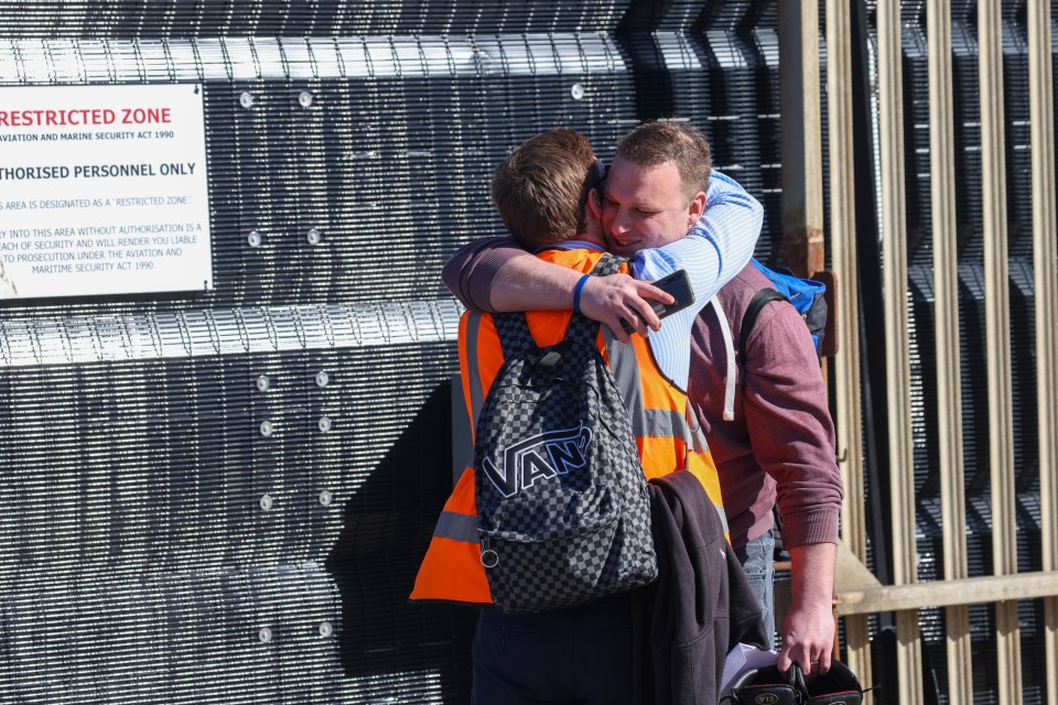 Two workers hug after 800 crew were made redundant today