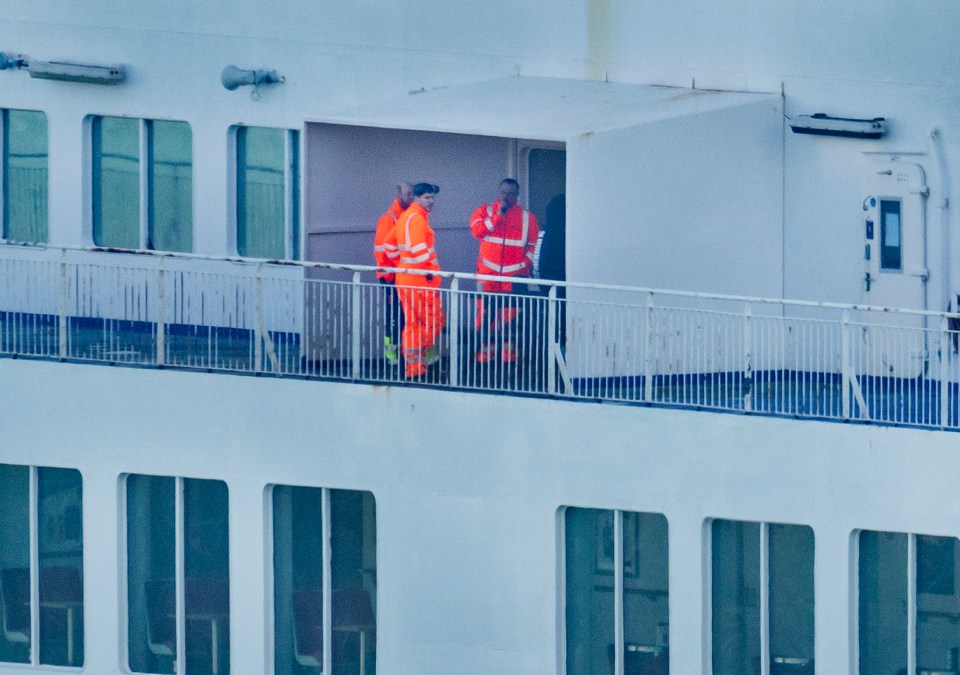 Workers are seen at the stern of the Spirit of Britain P&O ferry as she remains moored at Dover's Cruise Terminal in Kent