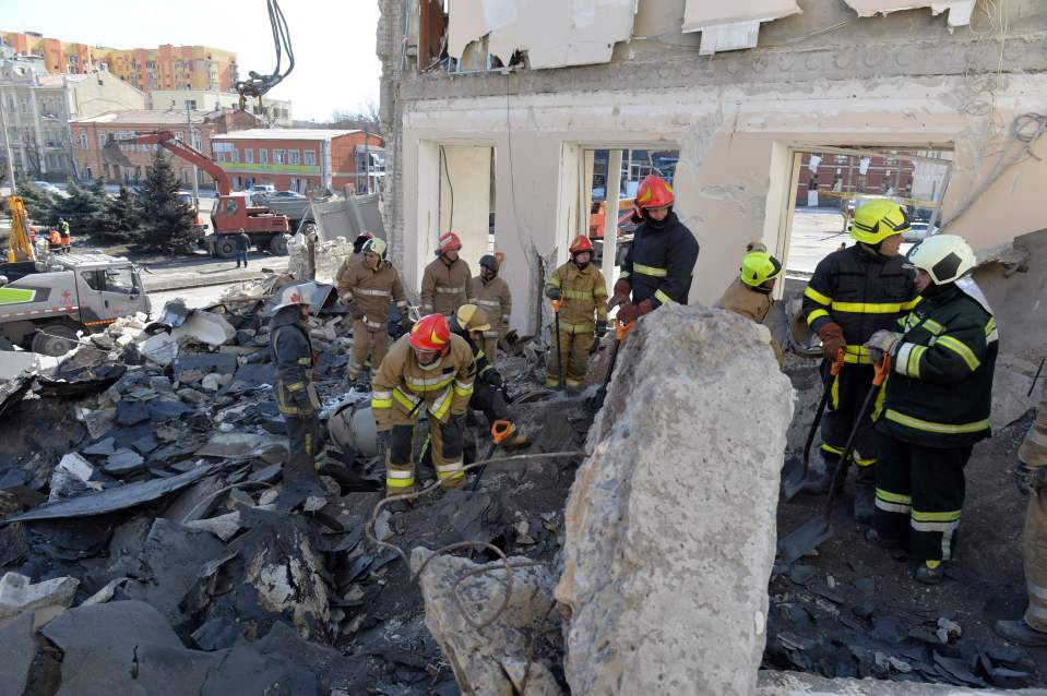 Rescue workers clear the rubble of a building in Kharkiv