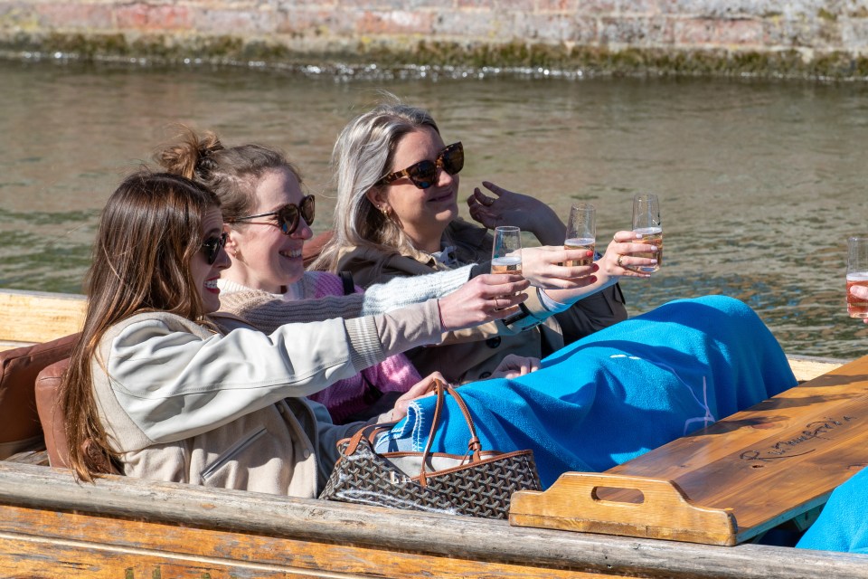 Women out punting on the River Cam in Cambridge enjoy the unseasonal warm weather