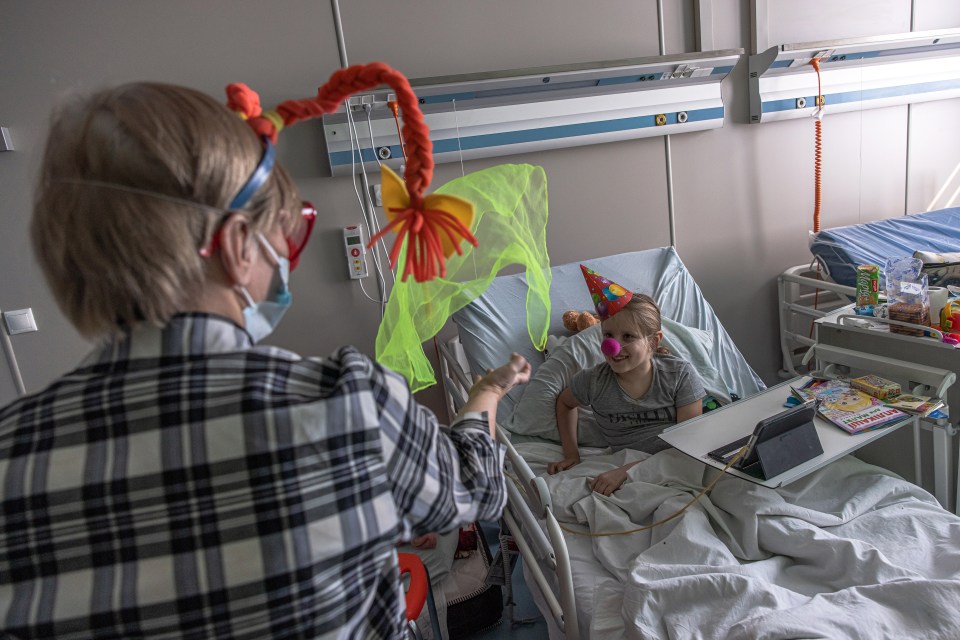 In a Kyiv hospital Milana, 6, who was injured while her mother Diana was killed on 28 February, plays with a clown