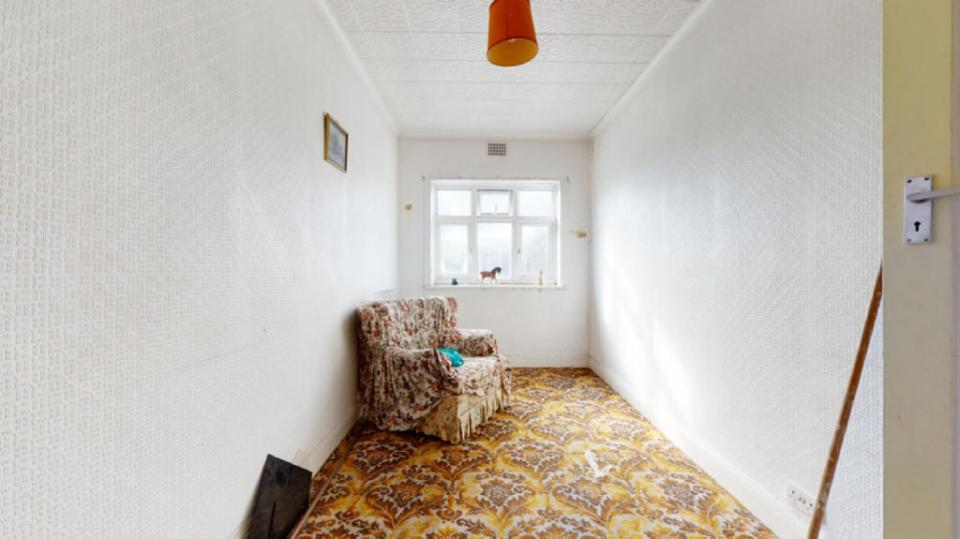 The property has a dated armchair and carpet