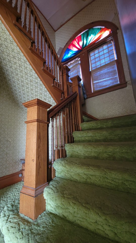 It features a wooden staircase leading to three large bedrooms and a bathroom upstairs