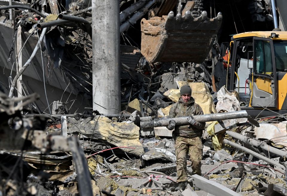 A Ukrainian serviceman outside a building in Kyiv after it was destroyed by Russian shelling