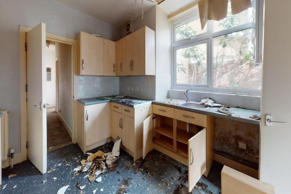 Elsewhere, a kitchen as been partly torn apart, with debris from a collapsed ceiling on the lino