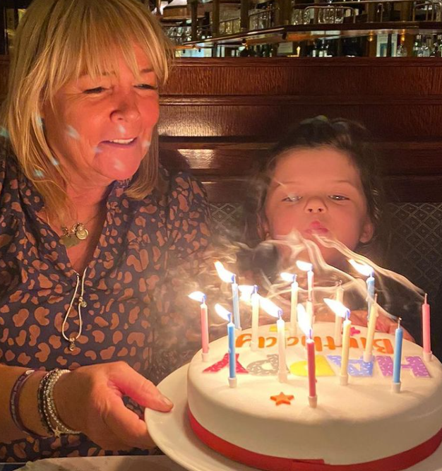 Linda's granddaughter helped her blow out the candles