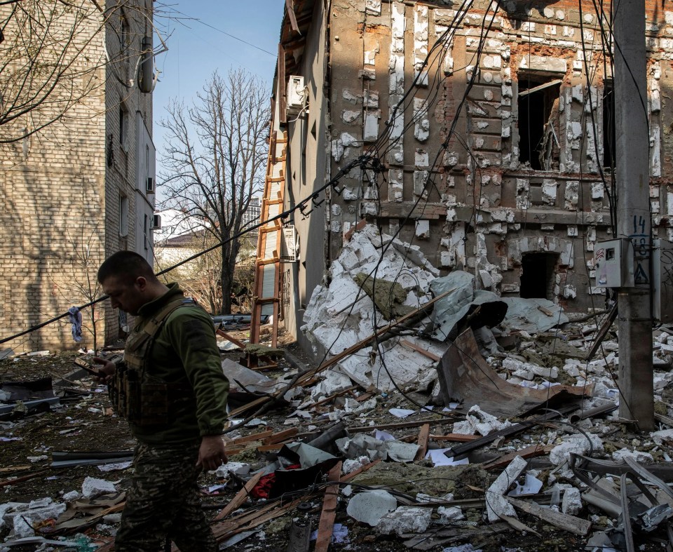 A Ukrainian military soldier walks on the debris caused by Russian shelling in Kharkiv