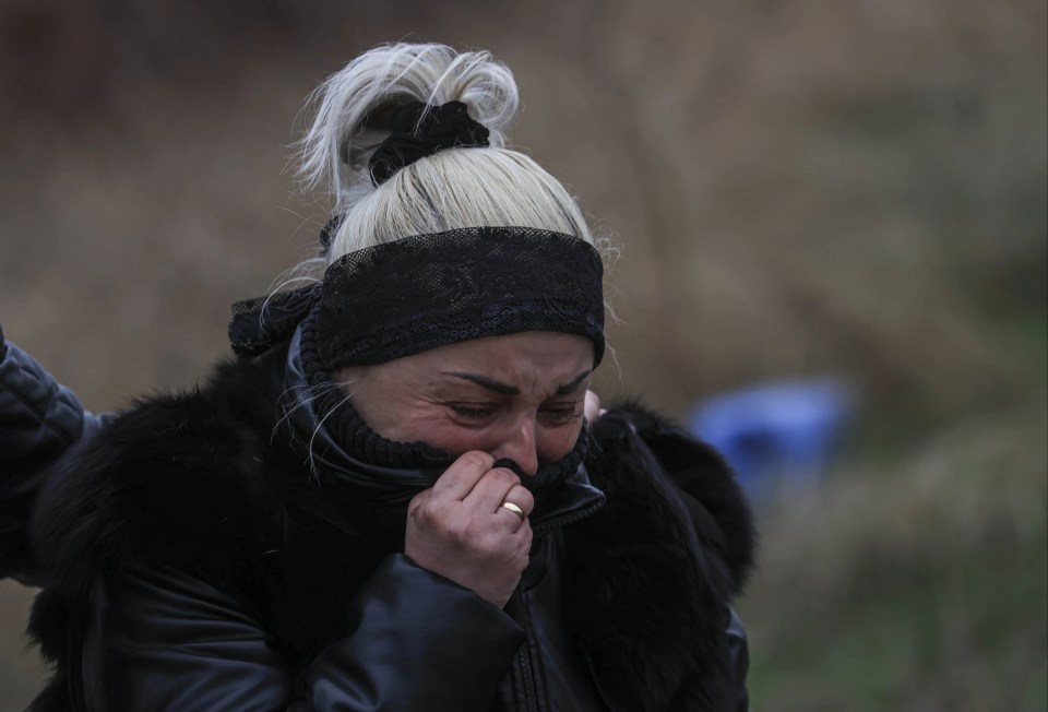 A woman cries after she identifies the corpse of her relative found in a mass grave in Bucha