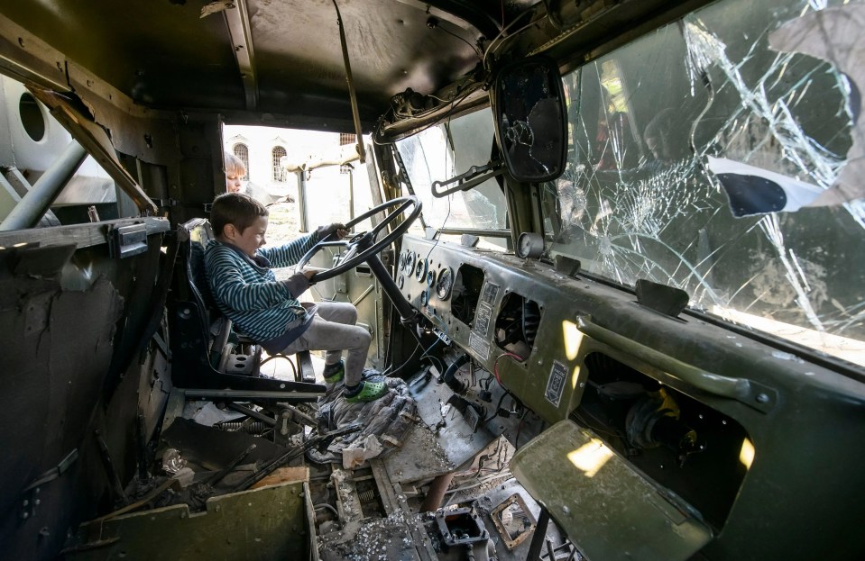 One of the kids pretends to drive the vehicle as he holds on to the steering wheel