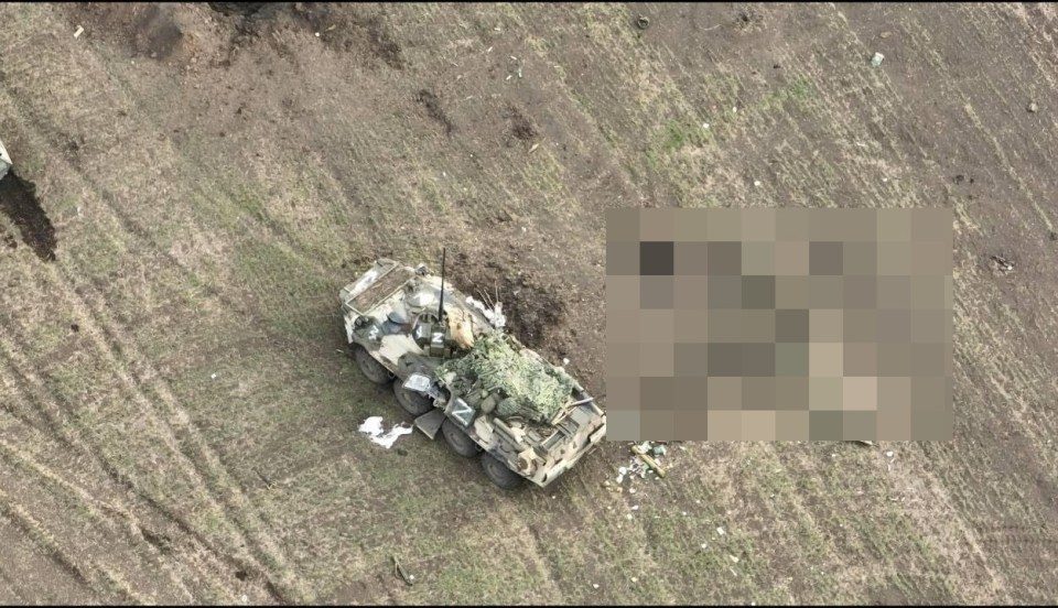 The Russian armoured personnel carrier lies destroyed beside them