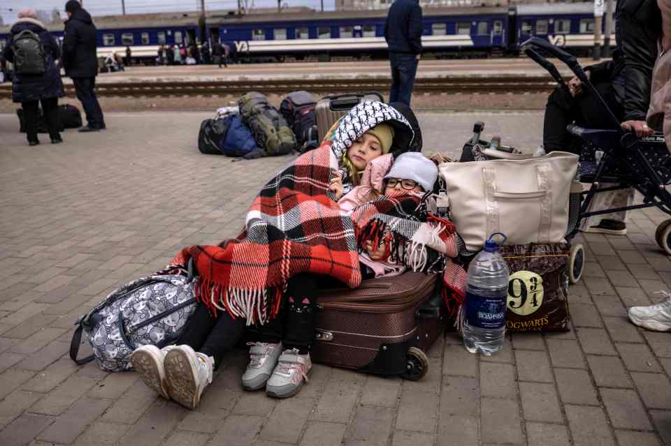 Children were pictured resting on luggage as families waited to board to train in the city of Kramatorsk