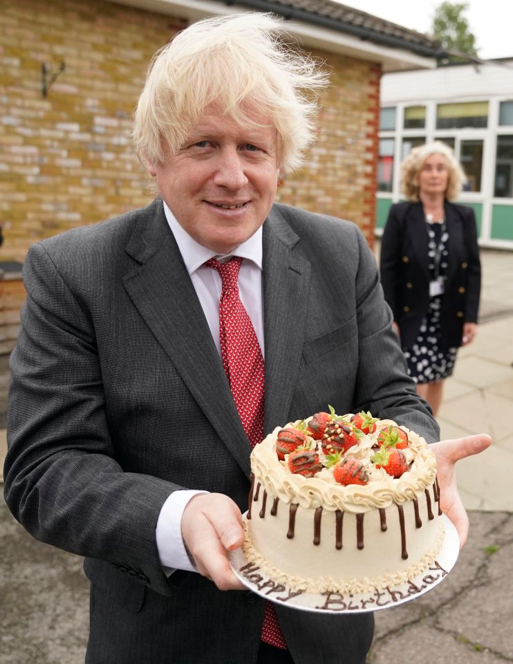 Boris Johnson receives a birthday cake from pupils at Bovingdon School hours before he attended a gathering in the Cabinet room, for which he was fined