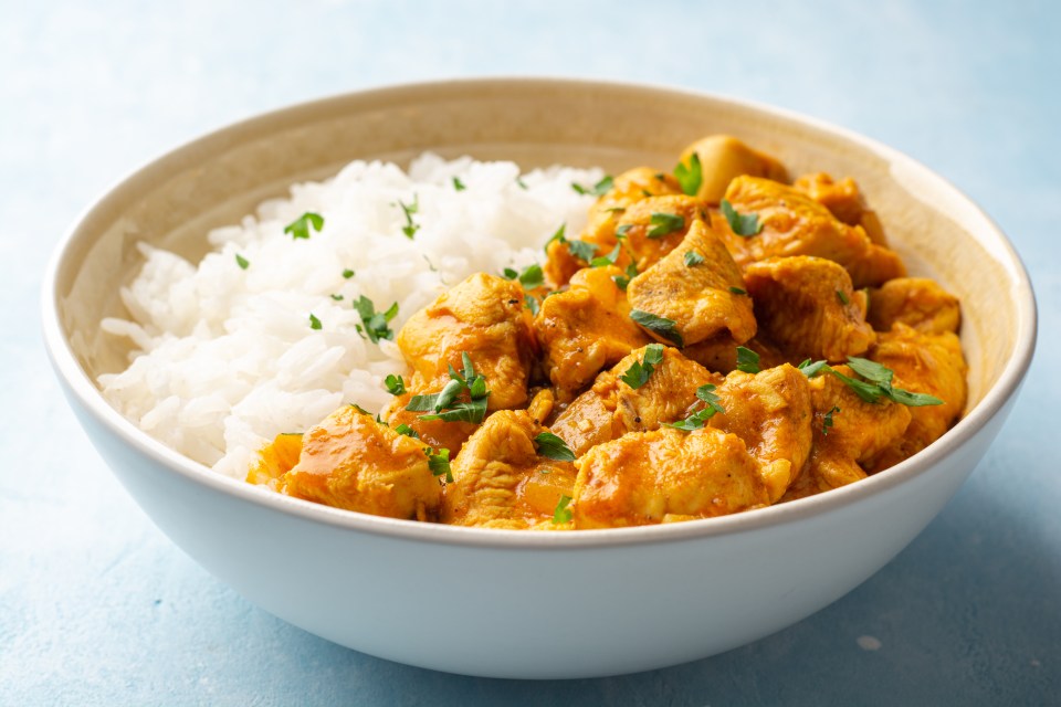 a bowl of chicken and rice with parsley on top