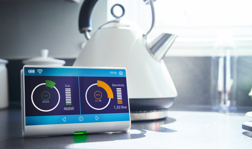 A smart meter on a kitchen work surface showing the households current energy consumption and costs