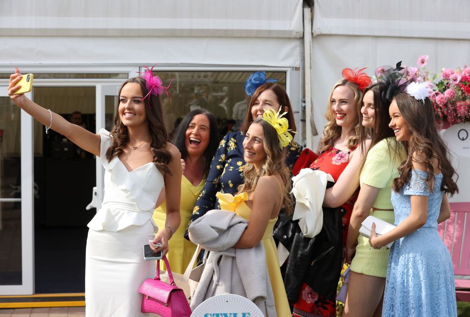 Racegoers pose for a selfie during the Coral Scottish Grand National