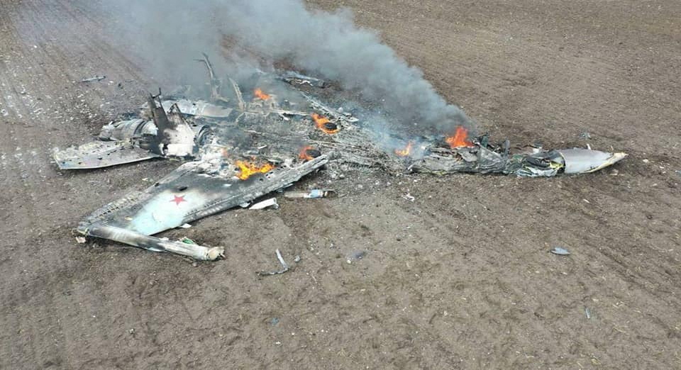 The wreckage of what is thought to be a Russian SU-35 can be seen burning in a field