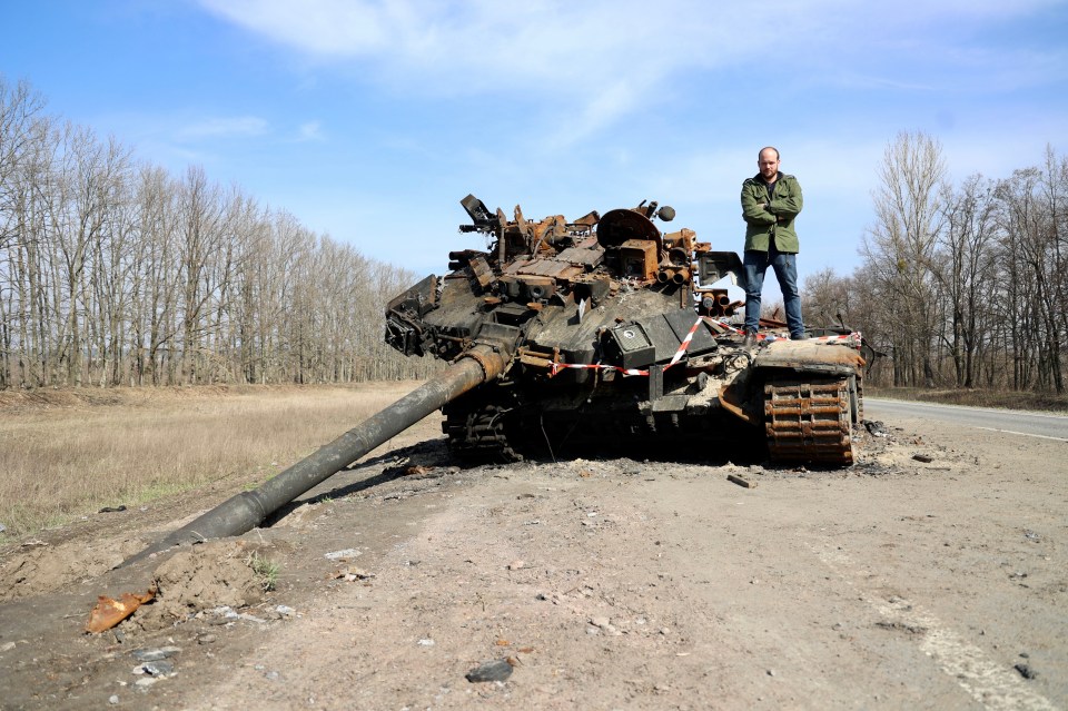 The Sun’s Jerome Starkey stands on a destroyed Russian battle tank