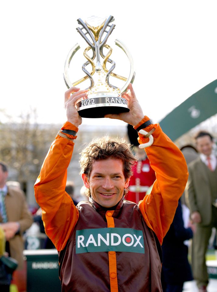 Waley-Cohen, an amateur jockey who owns a dental company, holds the Grand National trophy up after a miracle 50-1 victory at Aintree in his last ever ride