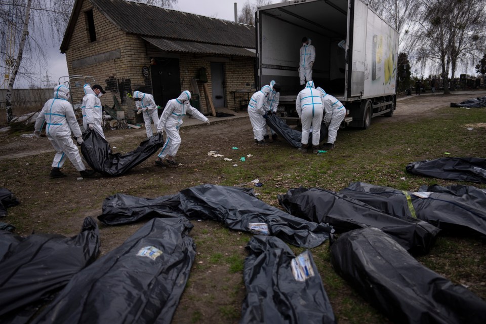 Volunteers load bodies of civilians killed in Bucha onto a truck to be taken to a morgue for investigation