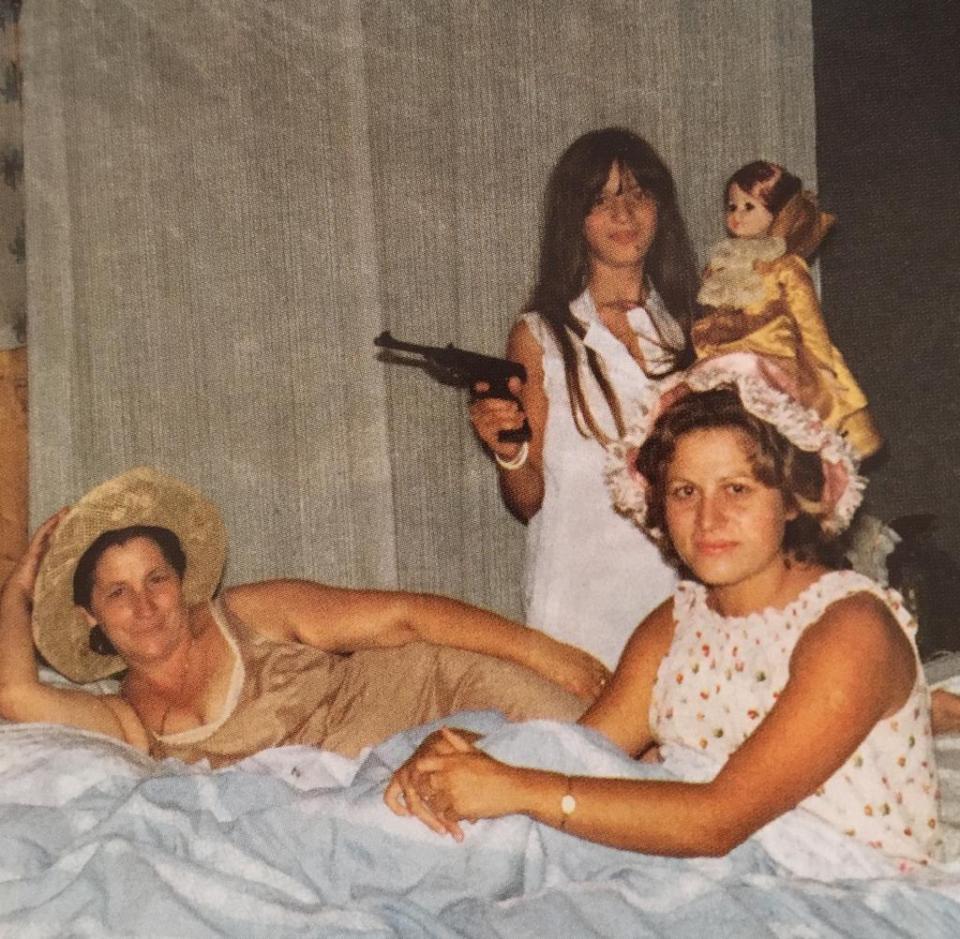 Marisa Merico points gun aged 11 in front of clan Godmother Maria Serraino laying on the bed