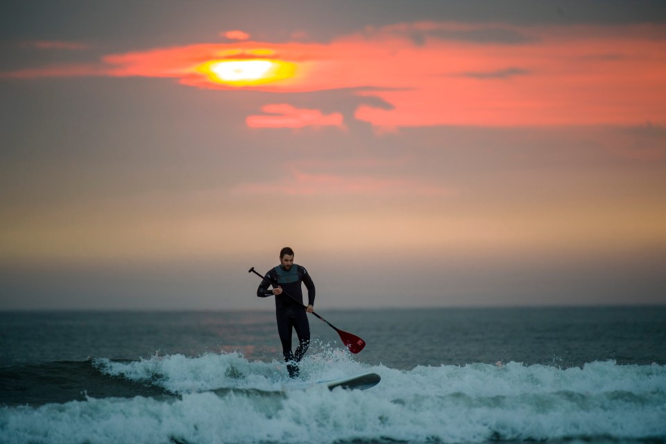 Paddle boarder Michael Morris, 36, paddles at sunrise in Belhaven Bay, East Lothian, Scotland