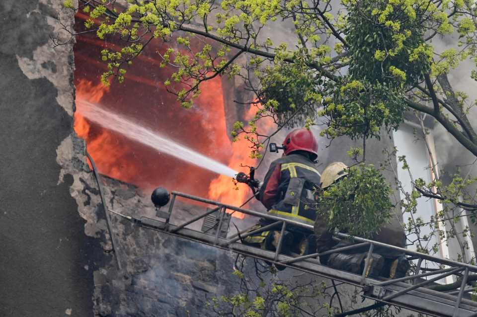 Firefighters try to put out a fire in a residential building in Kharkiv