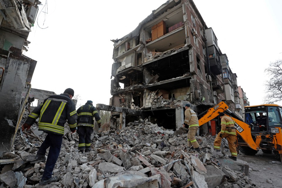 Rescuers work at a residential building damaged in Mariupol