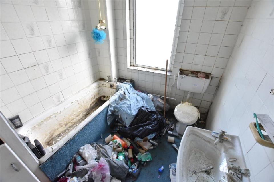 The bathroom is a complete mess too with the wash basin and bath covered in dirt and grime