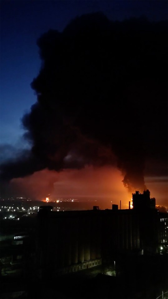 A huge plume of black smoke rises over the city