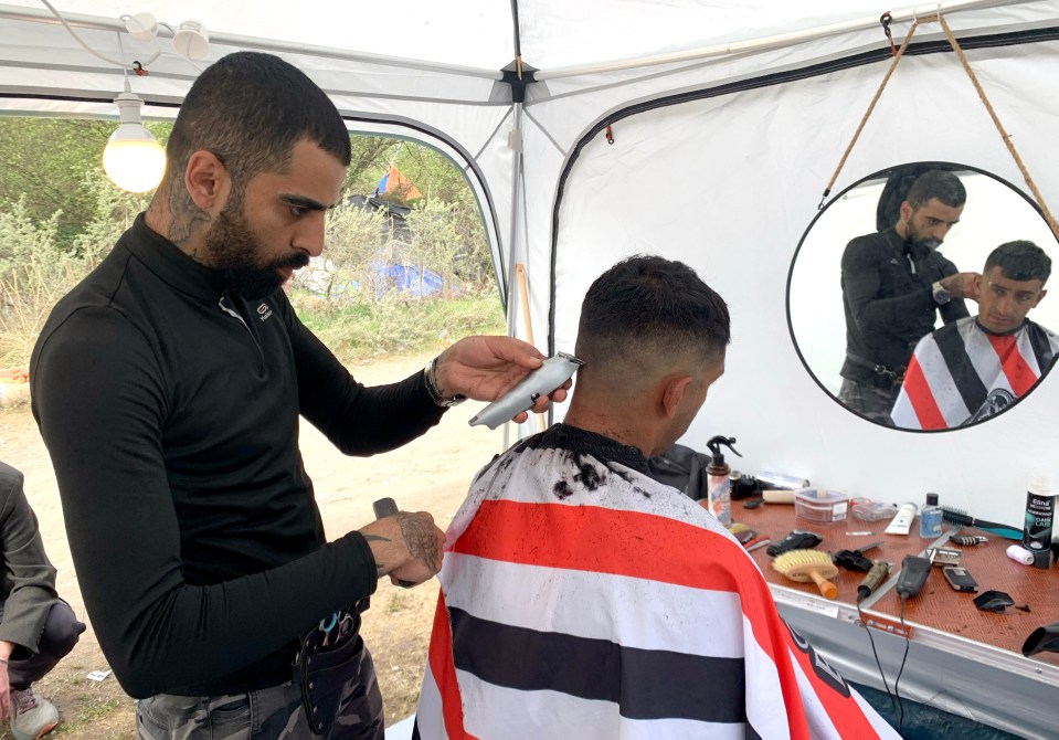 Tattooed Paywand, 24, from Iraq, is offering short-back-and-side cuts for £8 at the camp