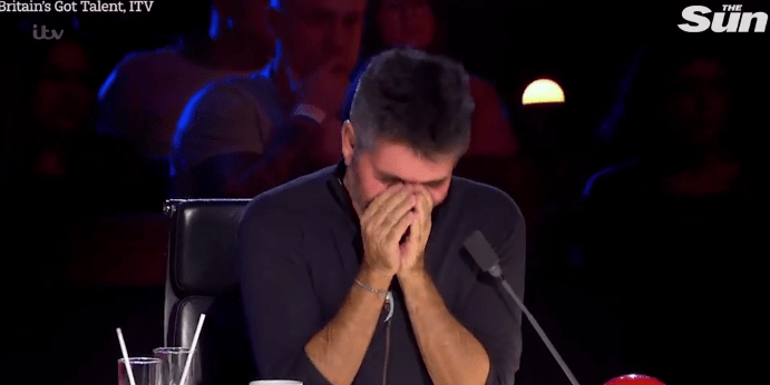 Simon Cowell held his hands to his face